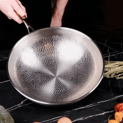 Wok martelé en titane Maison Ferré® tenu à deux mains